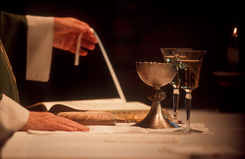 Father Joseph Byrne of Holy Cross Parish in Townsend, Mont., blesses the host during the Eucharistic offering of the Mass.