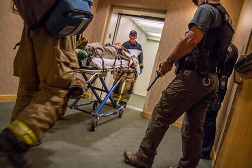 Emergency responders take the subdued and injured assailant down to a waiting ambulance at the end of an &ldquo;Active Shooter&rdquo; drill.