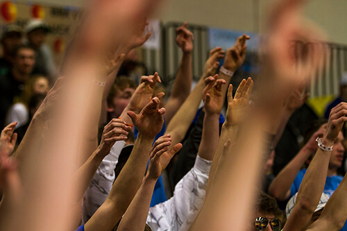 The Malta student section fans hold up crossed fingers during the 2015 State B Basketball Tournament.