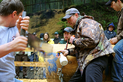 UM Woodsmans' Team co-captain Dan Marvin seconds his sawyers Brock Martin and Eric Hoberg with wedge and WD-40 as they compete in the Men's Double Buck contest during the annual regional Conclave meet.